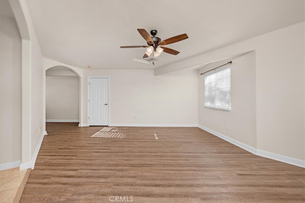 3271 East Muscat Avenue Fresno, CA 93725 - Photo 30 of 53 an empty room with wooden floor ceiling fan and windows