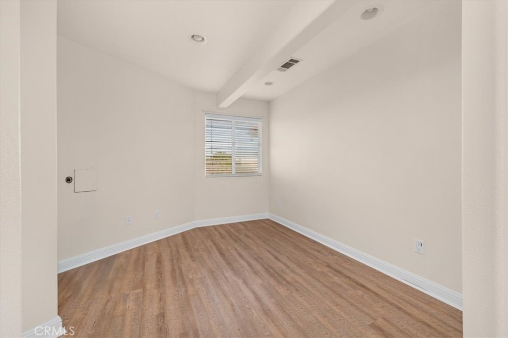 3271 East Muscat Avenue Fresno, CA 93725 - Photo 32 of 53 an empty room with wooden floor and windows