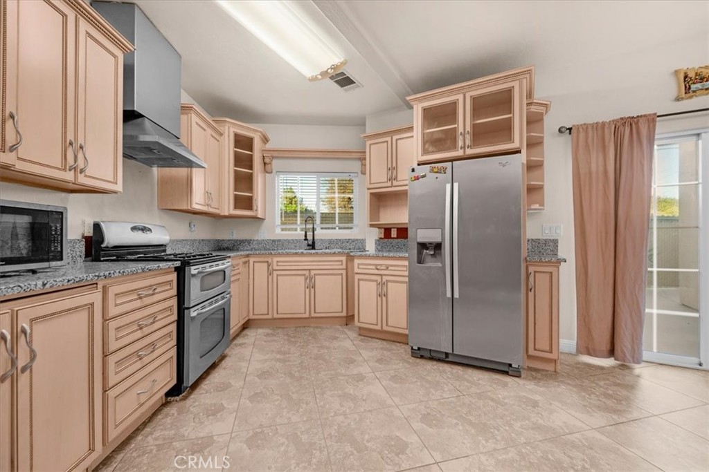 3271 East Muscat Avenue Fresno, CA 93725 - Photo 4 of 53 a kitchen with a refrigerator sink and cabinets