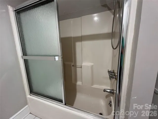 a bathroom with a glass door shower and a sink