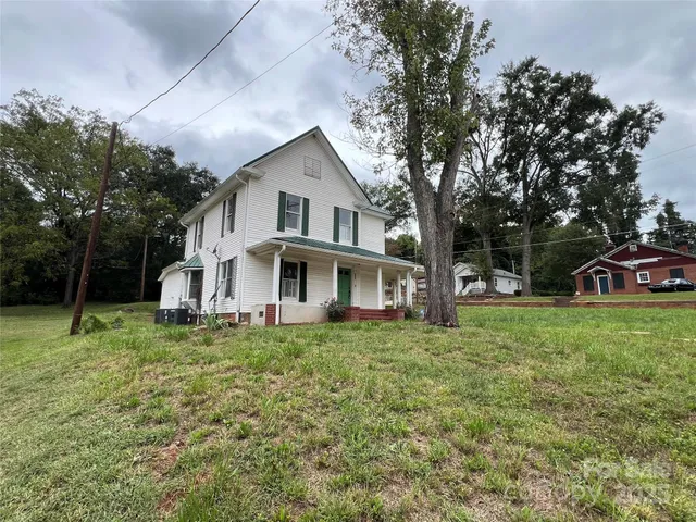 a white house that has a tree in front of it