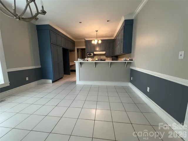 a view of a kitchen with kitchen island granite countertop a refrigerator and a stove top oven