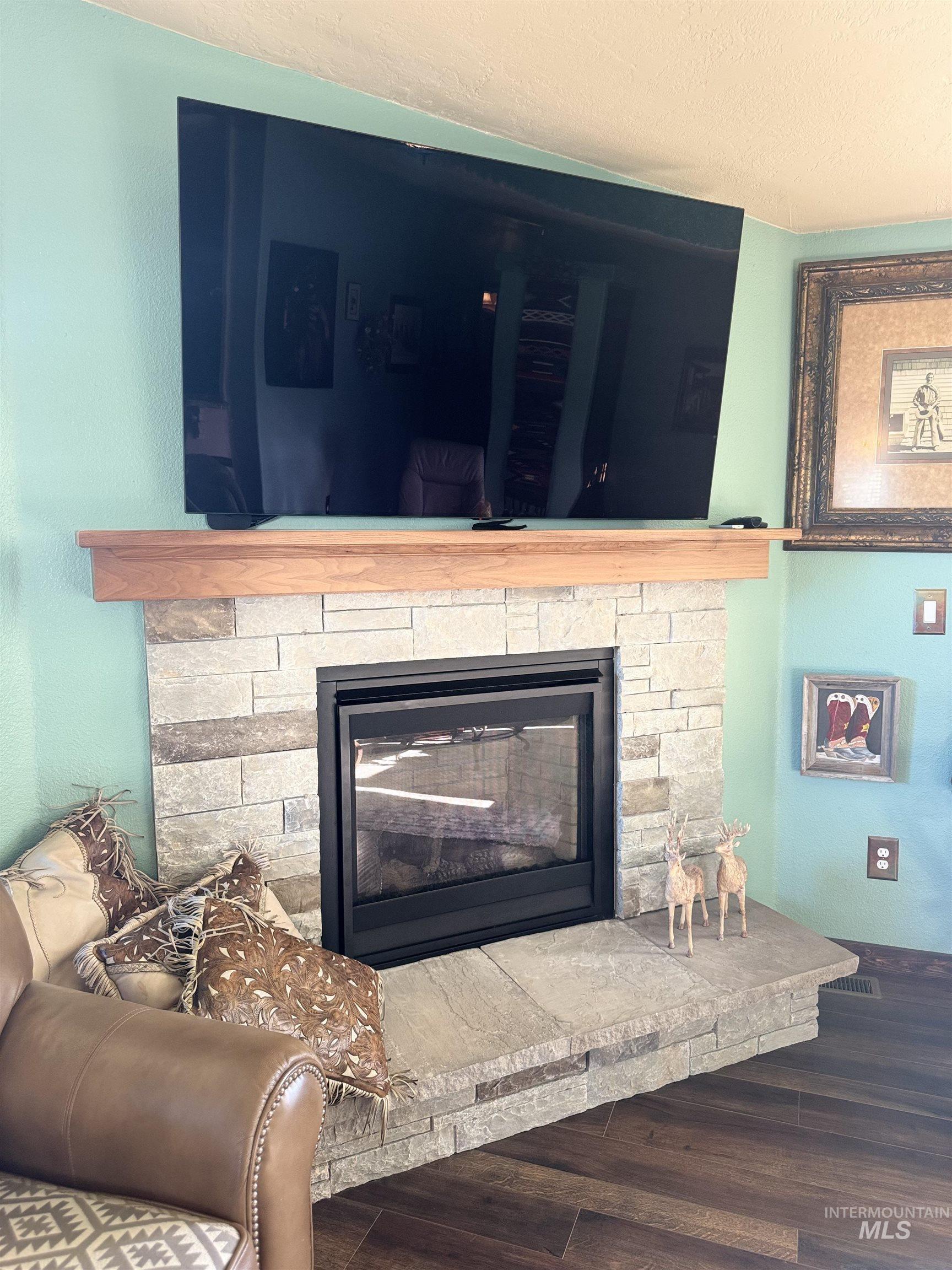 811 14th Street Clarkston, WA 99403 - Photo 12 of 50 Detailed view of wood finished floors, a fireplace, and a textured ceiling