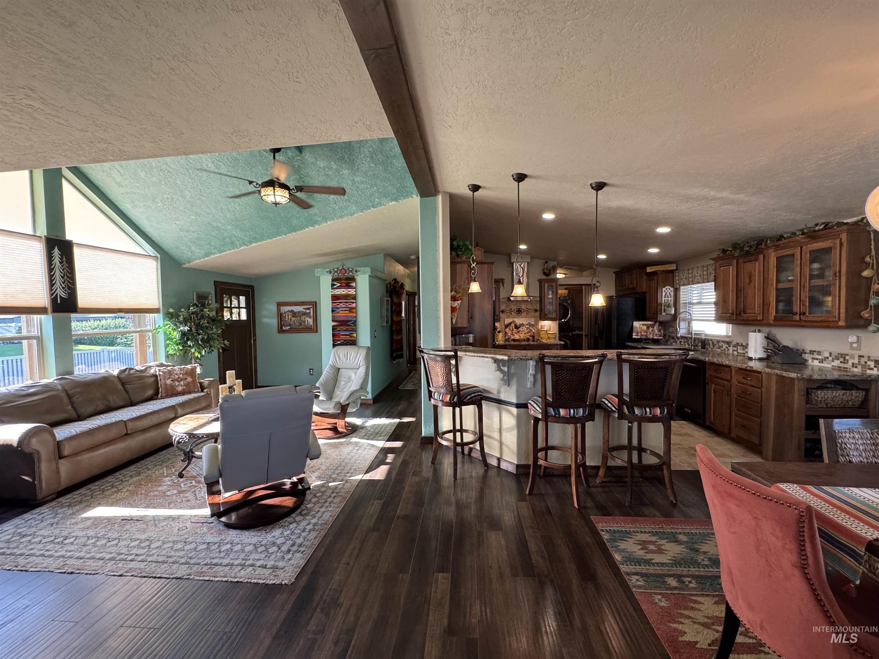 811 14th Street Clarkston, WA 99403 - Photo 15 of 50 Living area featuring a textured ceiling, dark wood-style flooring, and ceiling fan
