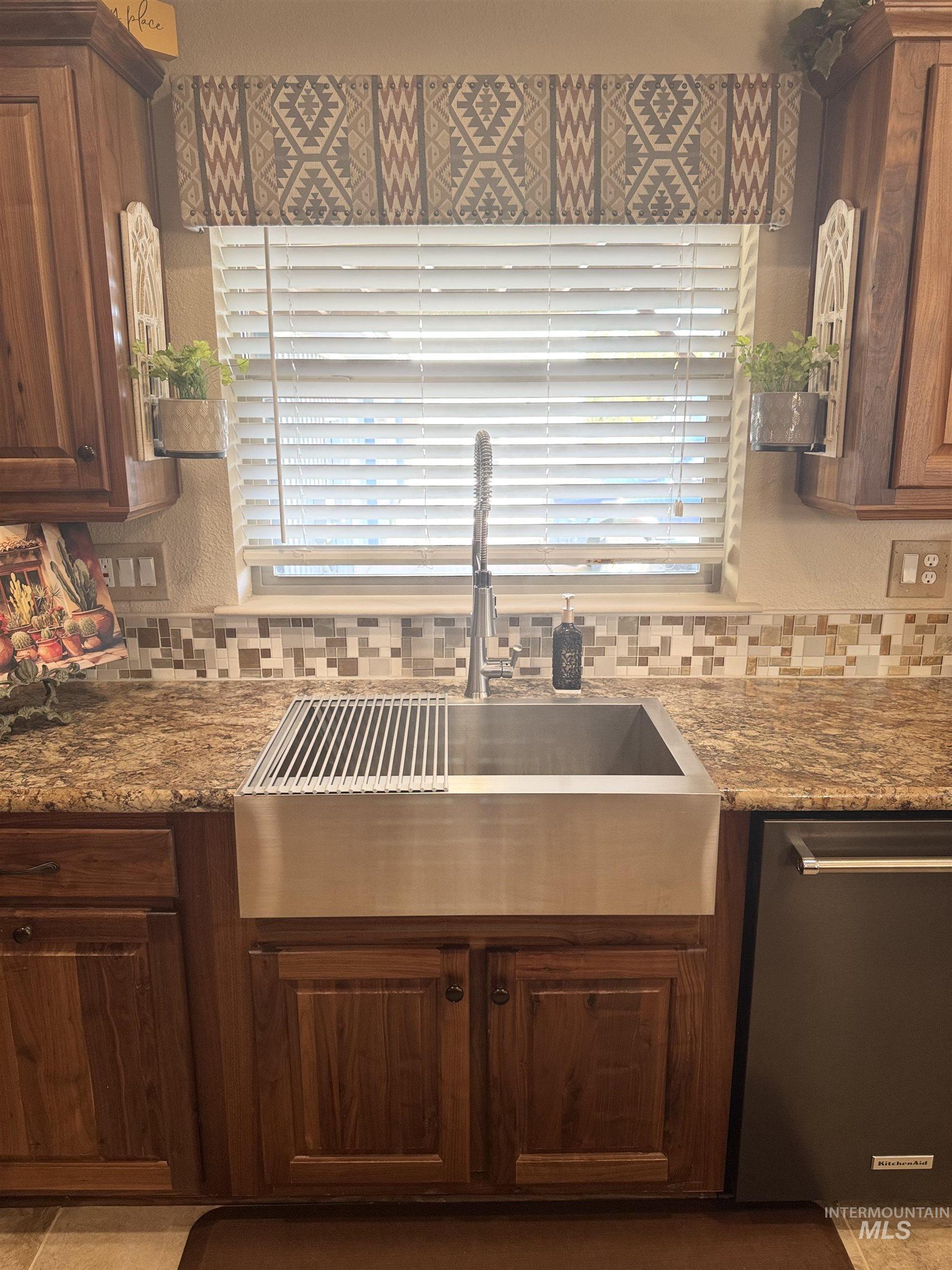 811 14th Street Clarkston, WA 99403 - Photo 20 of 50 Kitchen with stainless steel dishwasher, tasteful backsplash, tile patterned flooring, and dark stone countertops