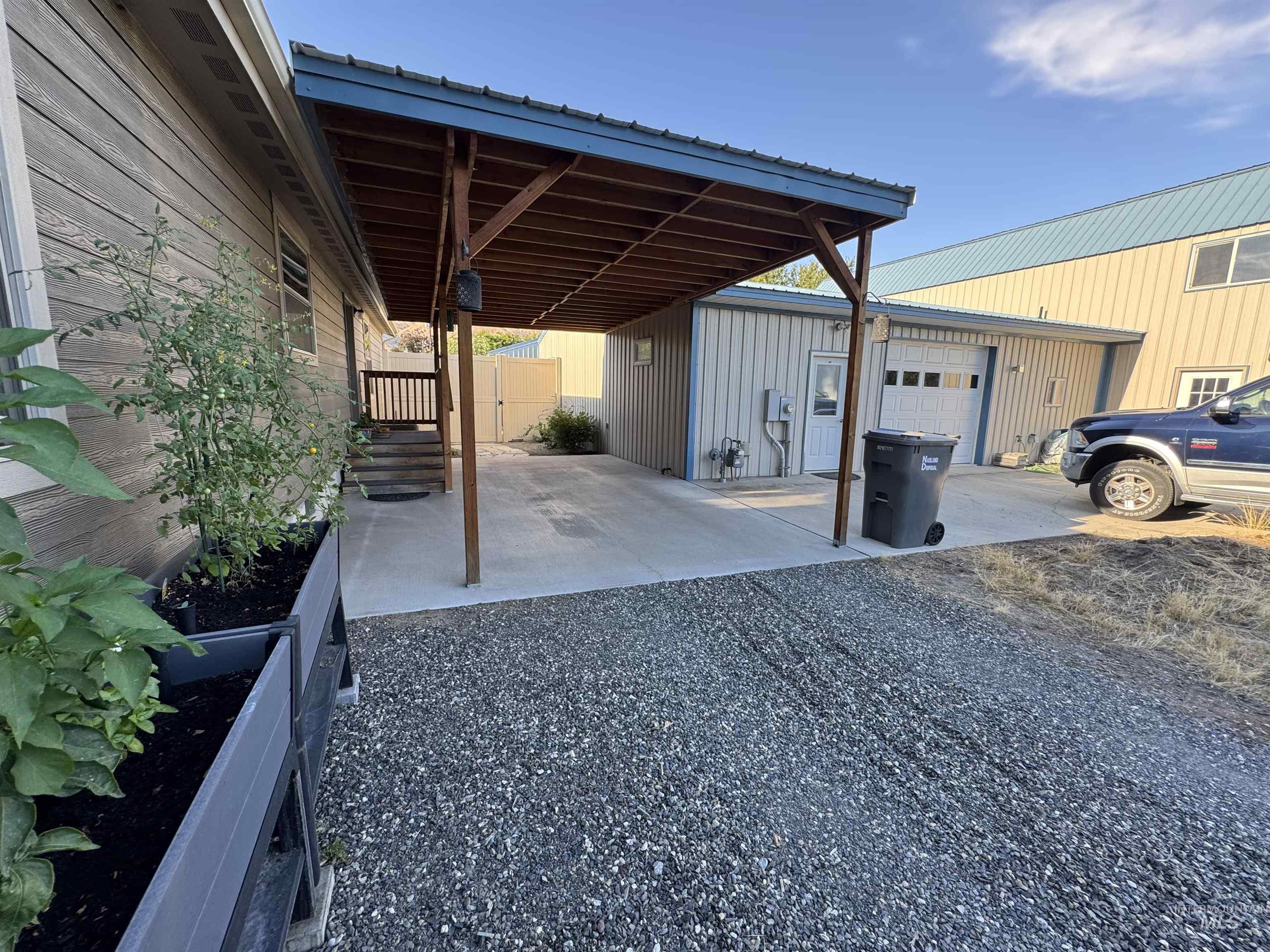 811 14th Street Clarkston, WA 99403 - Photo 36 of 50 View of patio featuring driveway, an attached garage, an outbuilding, and a carport