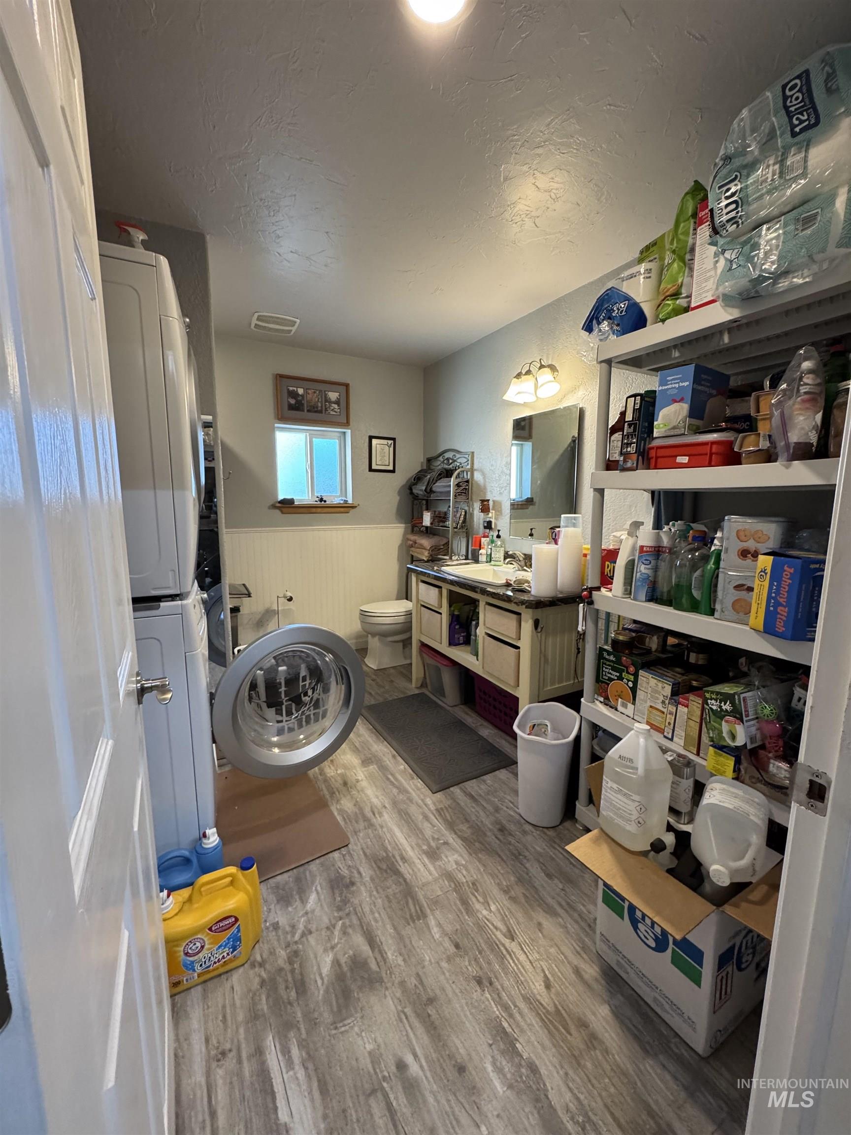 811 14th Street Clarkston, WA 99403 - Photo 44 of 50 Bathroom with a wainscoted wall, light wood-style floors, a textured ceiling, estacked washer and dryer, and vanity