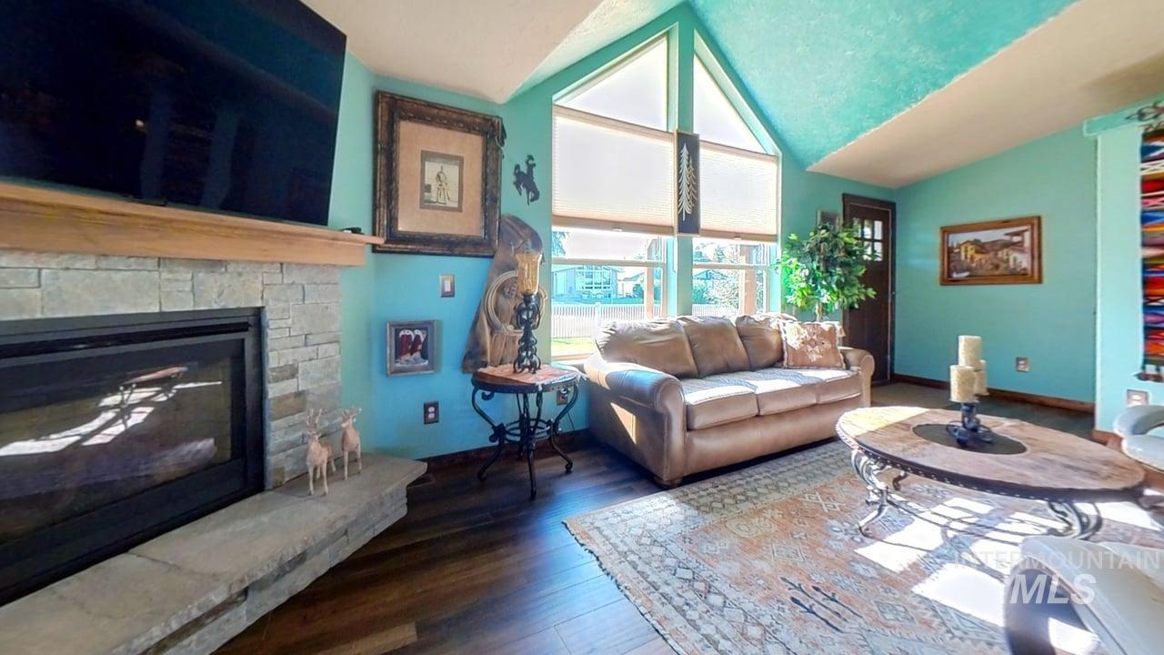 811 14th Street Clarkston, WA 99403 - Photo 10 of 50 Living room featuring wood finished floors, a fireplace, and vaulted ceiling