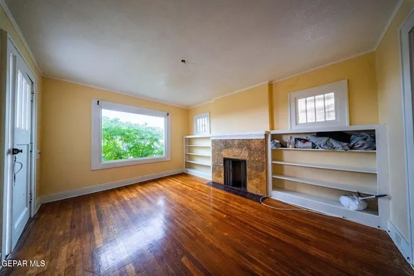a view of an empty room with a fireplace and a window