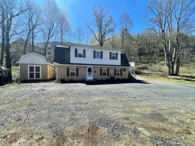 a front view of a house with a yard covered with snow