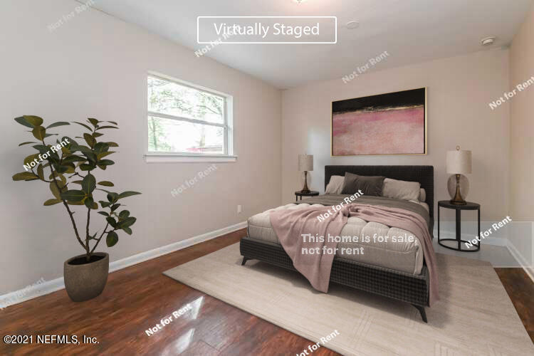 7320 Bamberg Road Jacksonville, FL 32277 - Photo 3 of 27 a bedroom with a large bed and a potted plant