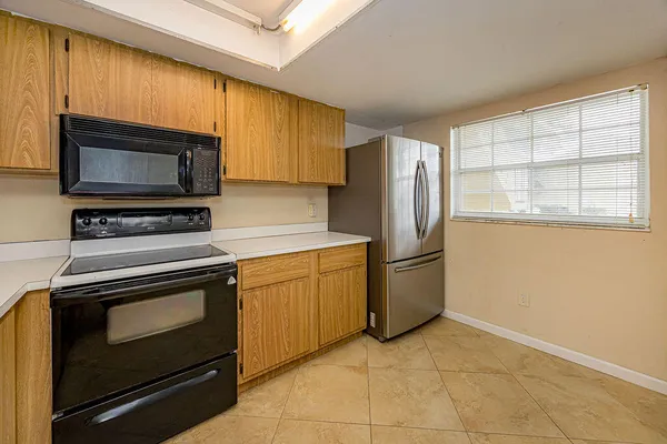 a kitchen with granite countertop a refrigerator stove and microwave