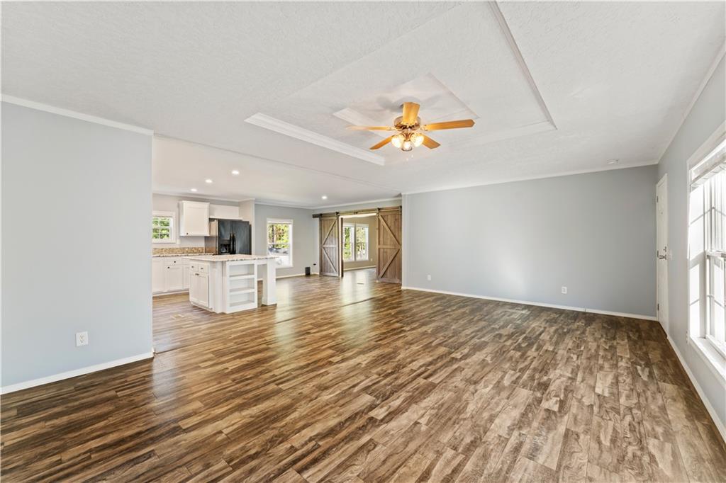 89 Ridge Road Seale, AL 36875 - Photo 8 of 46 Wood-finish flooring throughout, recessed ceiling with a central fan, and large windows provide natural light