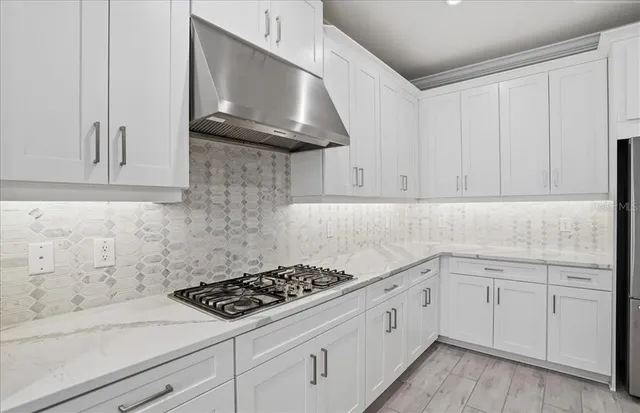 a dining room with stainless steel appliances kitchen island granite countertop a table chairs and a refrigerator
