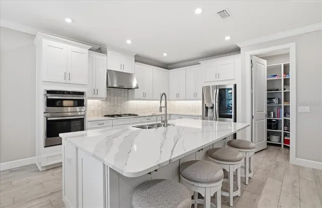 a kitchen with stainless steel appliances granite countertop a stove and a sink