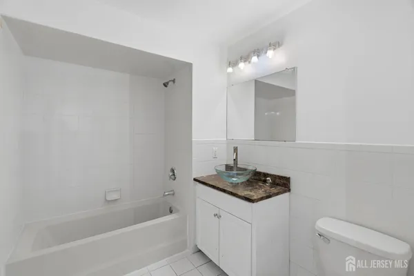 a bathroom with a granite countertop sink a toilet and bathtub