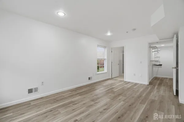 a view of empty room with wooden floor