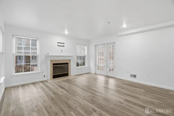 a view of empty room with wooden floor and fireplace