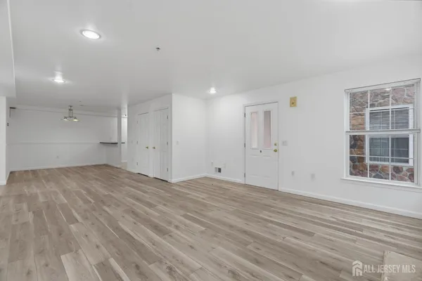 a view of empty room with wooden floor and windows