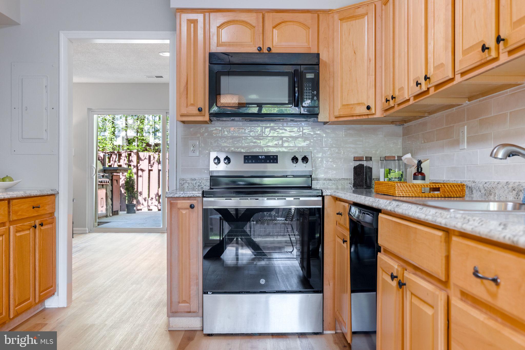 2389 Southgate Square Reston, VA 20191 - Photo 14 of 56 a kitchen with stainless steel appliances granite countertop a stove a microwave and cabinets