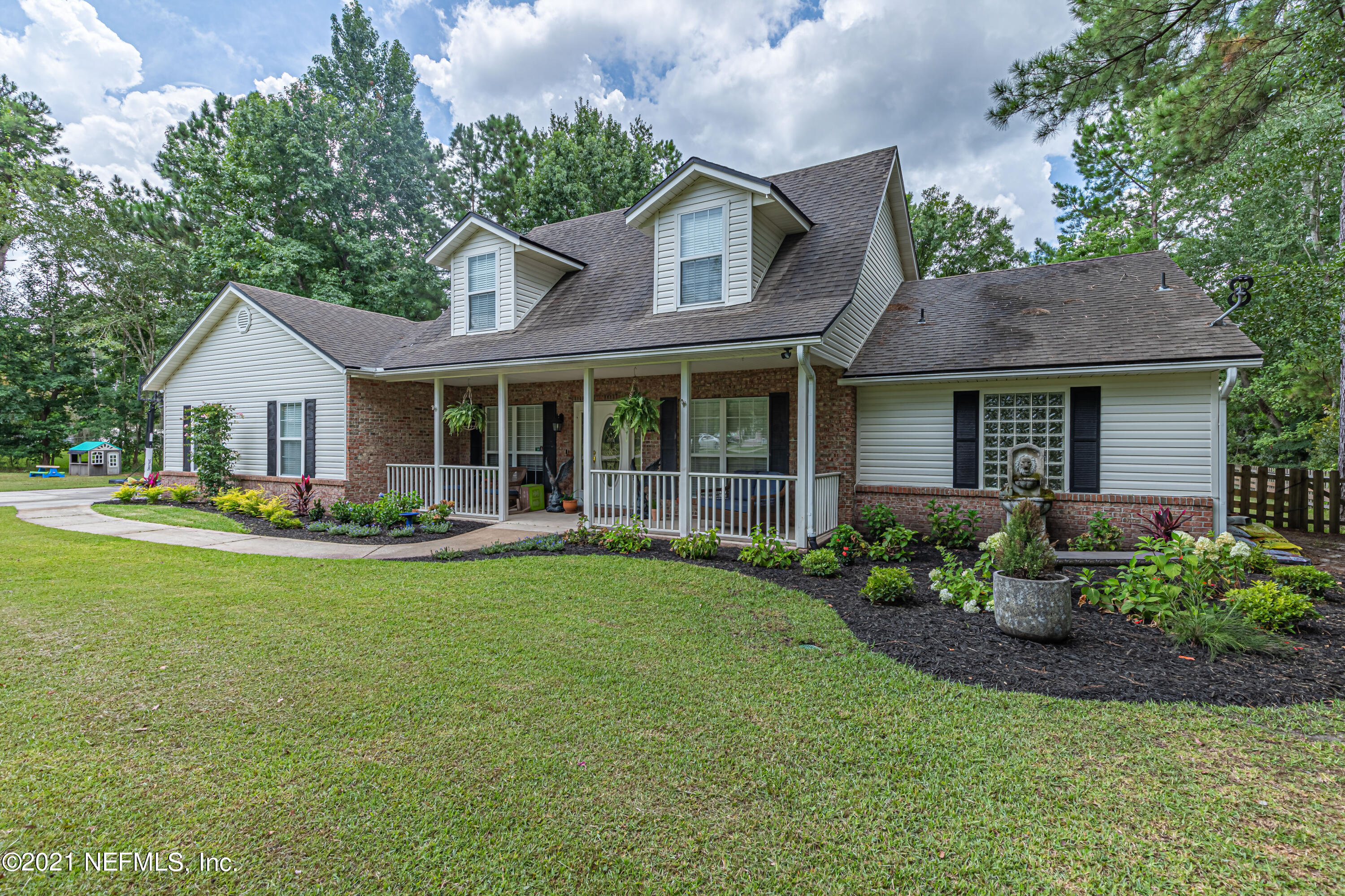 a front view of a house with a garden and porch