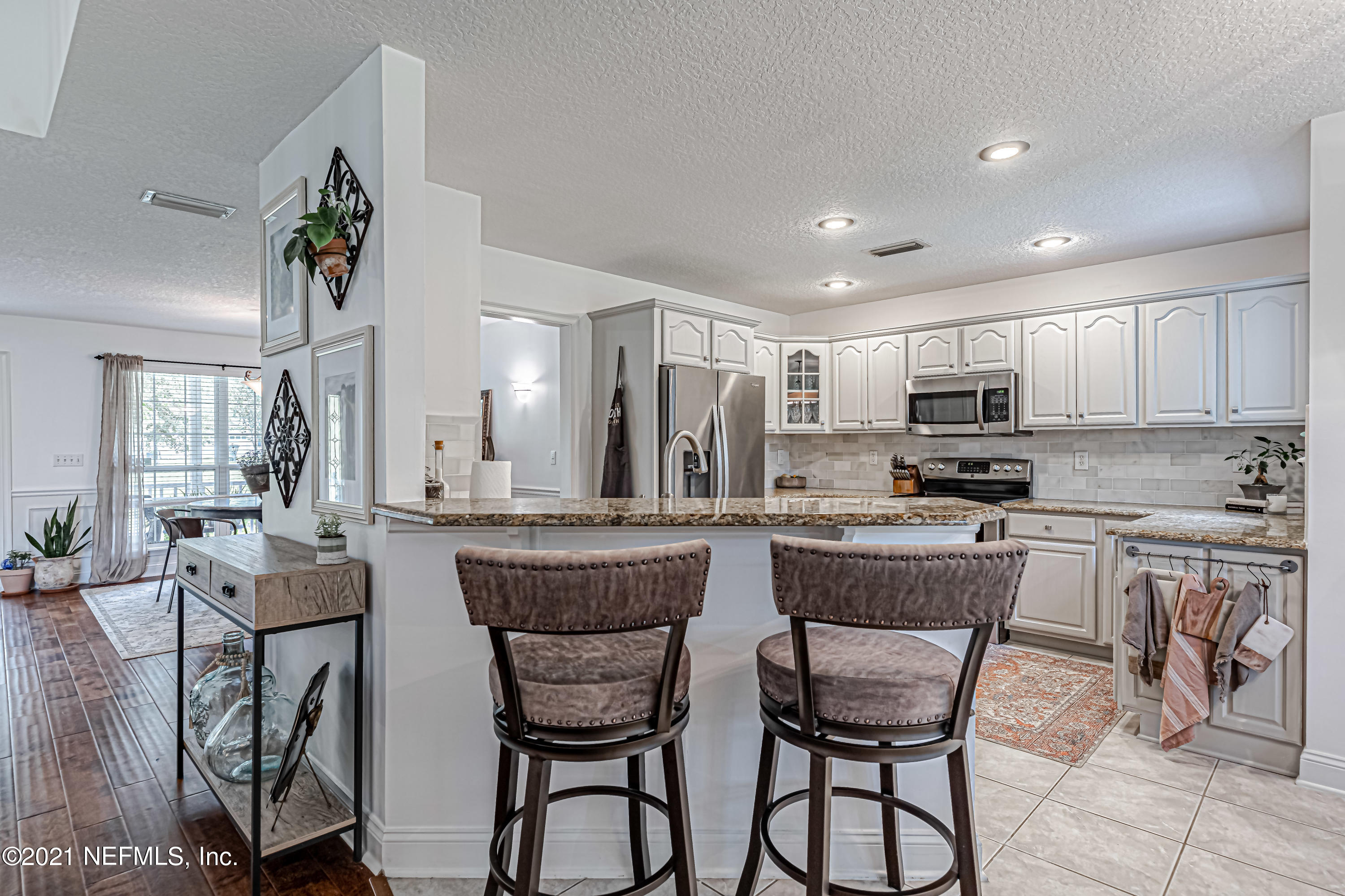 184 Circuit Rider Road Green Cove Springs, FL 32043 - Photo 22 of 58 a kitchen with stainless steel appliances kitchen island granite countertop a stove a sink a refrigerator dining table and chairs