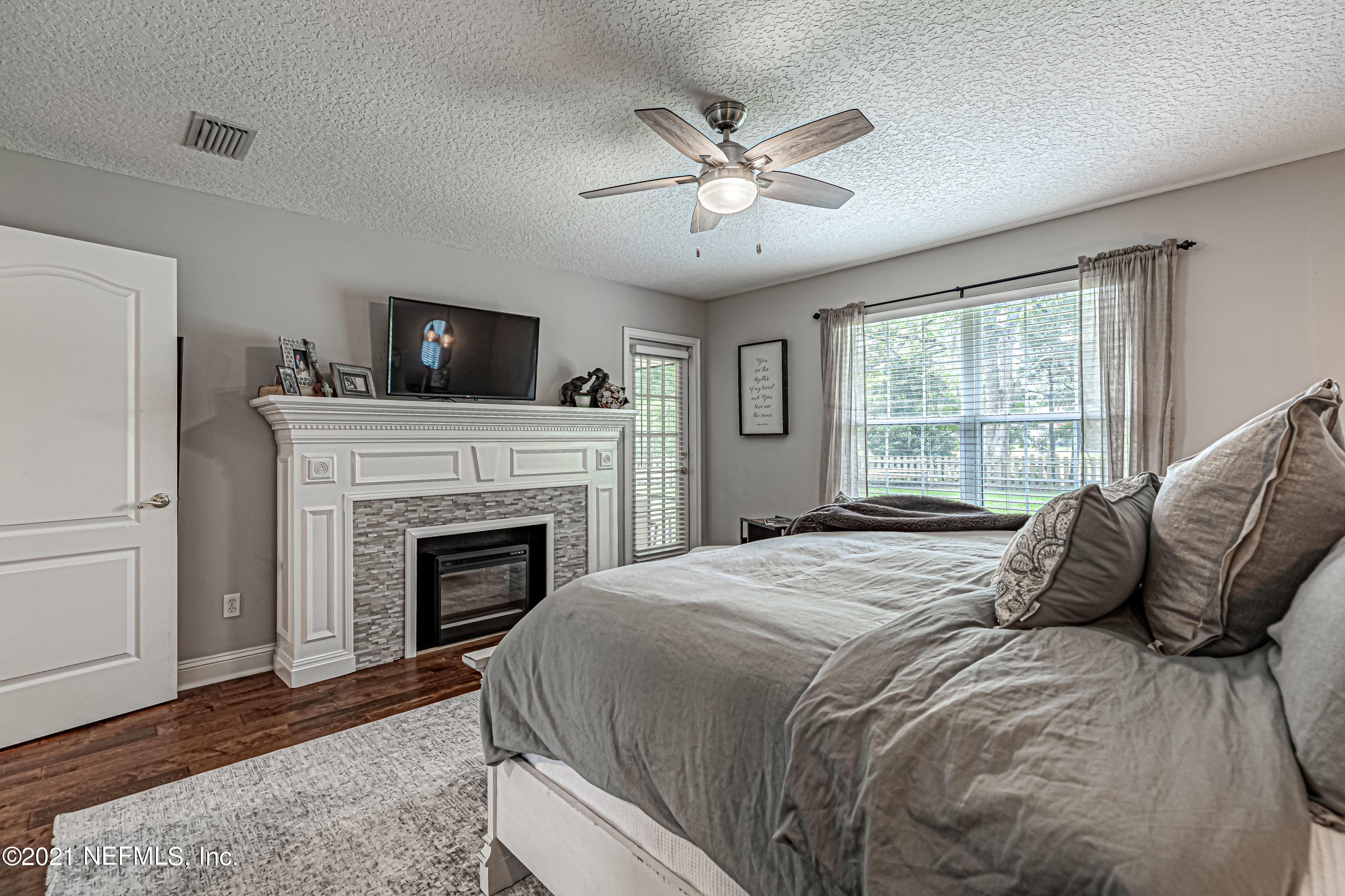 184 Circuit Rider Road Green Cove Springs, FL 32043 - Photo 29 of 58 a bedroom with a large bed and a fireplace