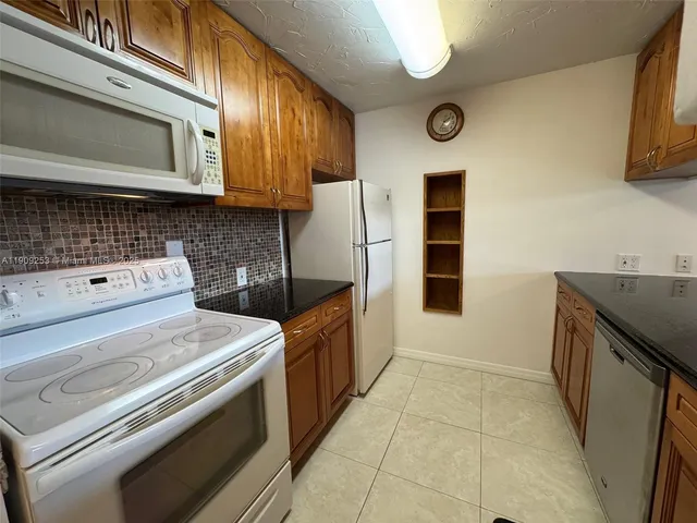 a kitchen with stainless steel appliances granite countertop a stove and a microwave