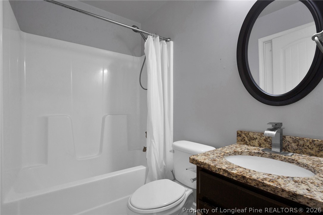 2145 Harrington Road Fayetteville, NC 28306 - Photo 44 of 50 a bathroom with a granite countertop sink toilet and a mirror