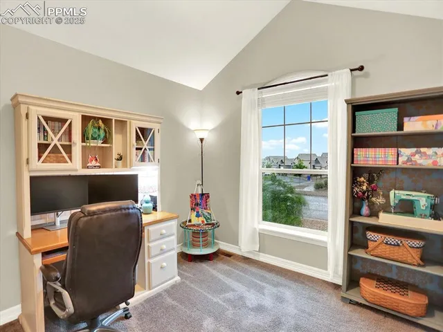 a view of a workspace with furniture and a window