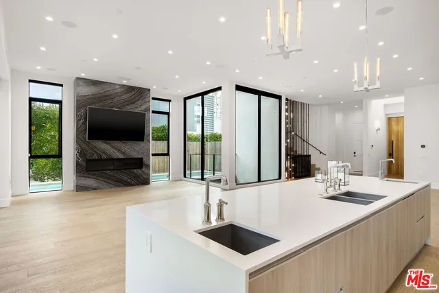 a kitchen with stainless steel appliances a sink and a large mirror