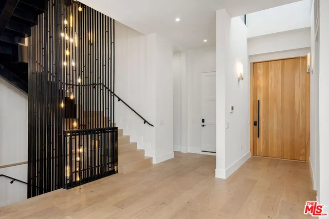 a view of a hallway with wooden floor and entryway