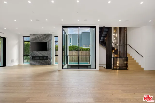 a view of a hallway with wooden floor and windows