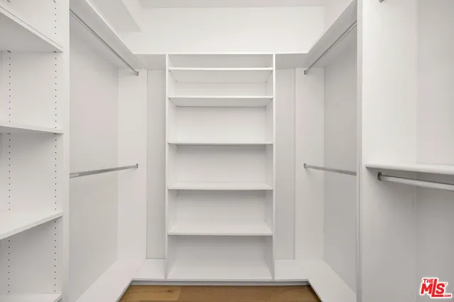 a view of walk in closet with empty racks