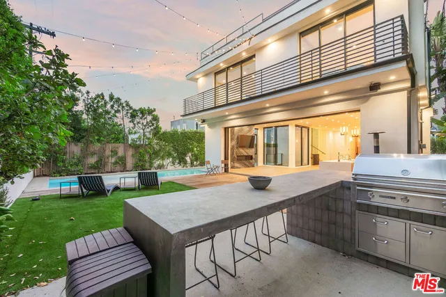 a view of a patio with table and chairs a barbeque with potted plants and floor to ceiling window