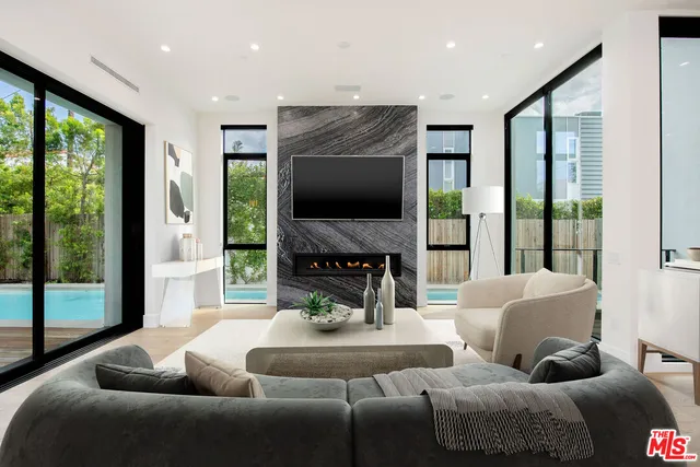 a living room with furniture a large window and a flat screen tv