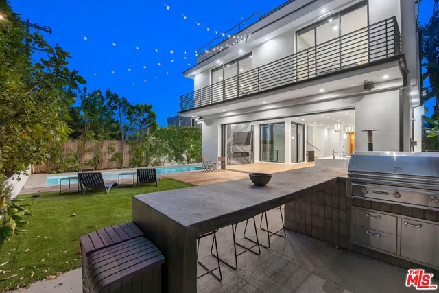 a view of a house with backyard and sitting area