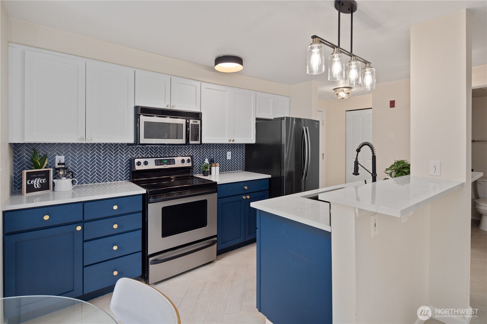 300 10th Avenue, Unit A302 Seattle, WA 98122 - Photo 13 of 27 a kitchen with stainless steel appliances a sink a stove a refrigerator cabinets and a dining table