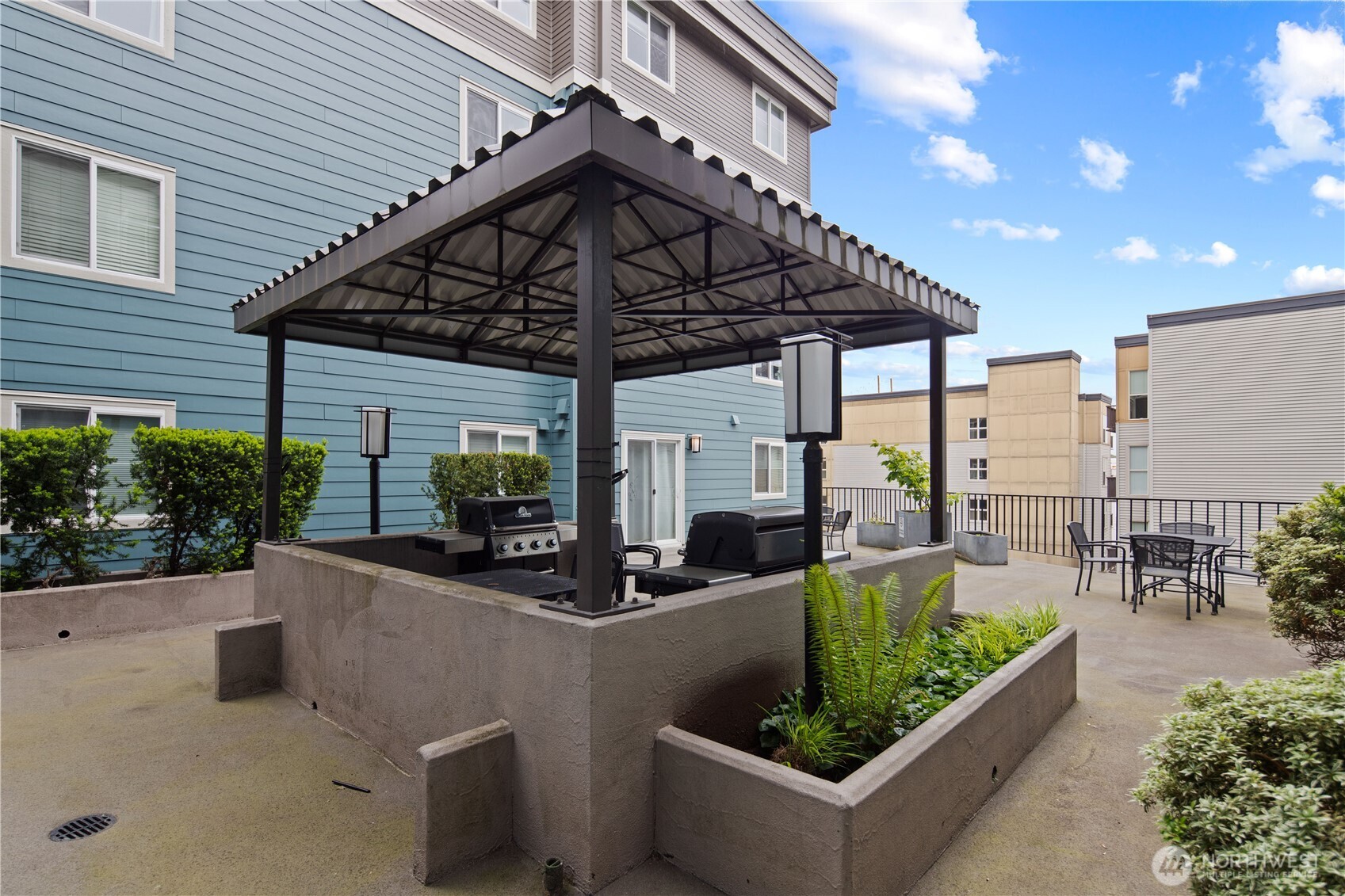 300 10th Avenue, Unit A302 Seattle, WA 98122 - Photo 22 of 27 a view of a patio with couches chairs potted plants and a table and chairs