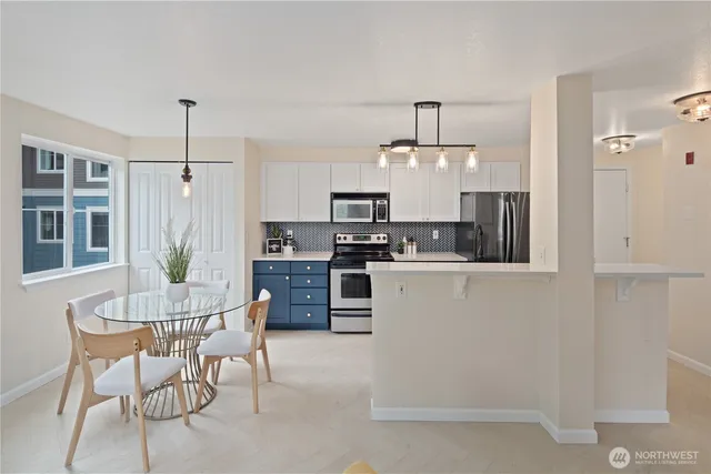 a kitchen with kitchen island granite countertop a sink cabinets and stainless steel appliances