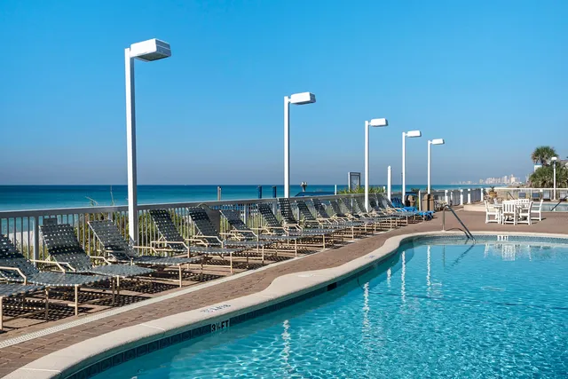 a view of a balcony with wooden floor and outdoor seating