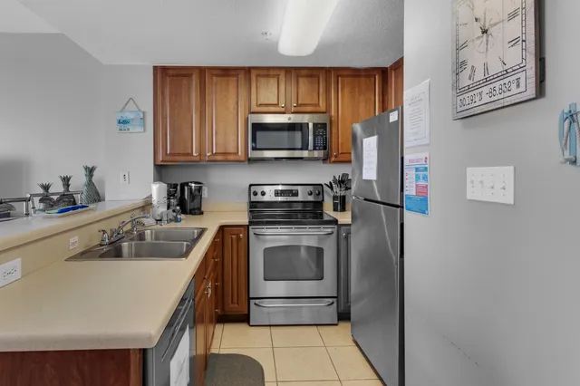 a kitchen with a sink a stove top oven and refrigerator