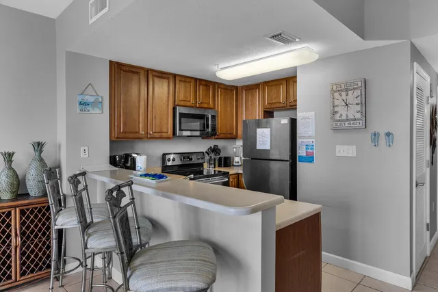 a kitchen with stainless steel appliances a refrigerator a stove a sink dishwasher and a refrigerator with wooden floor