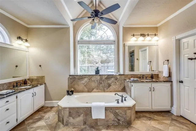 a large white tub sitting in a bathroom next to a window
