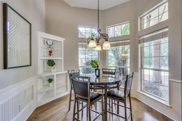 a view of a dining room with furniture a chandelier and wooden floor