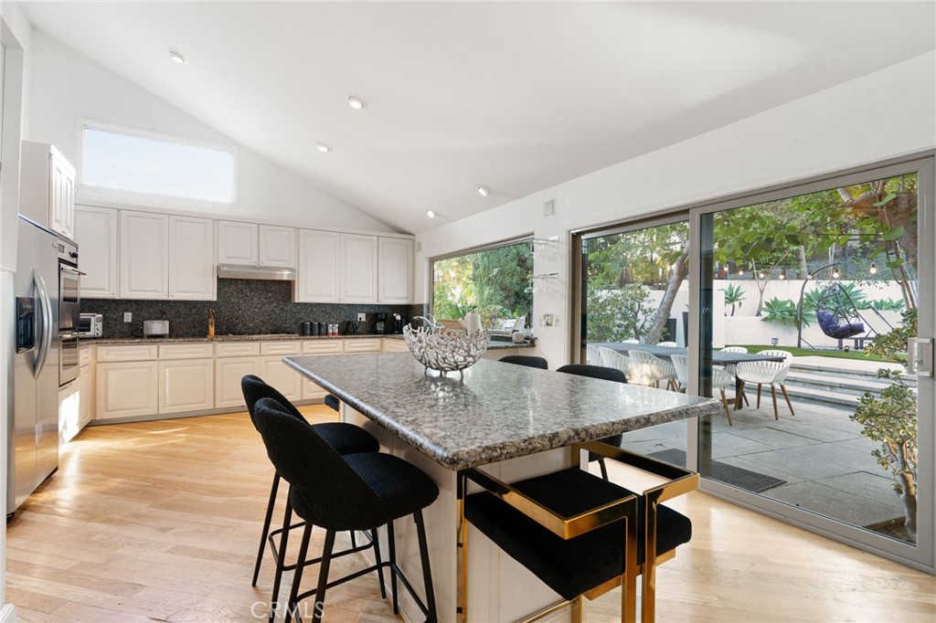 1447 North Kings Road West Hollywood, CA 90069 - Photo 11 of 40 a kitchen with a dining table chairs and granite counter tops