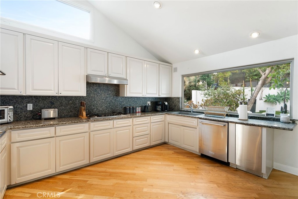 1447 North Kings Road West Hollywood, CA 90069 - Photo 10 of 40 a kitchen with stainless steel appliances granite countertop a stove a sink and white cabinets