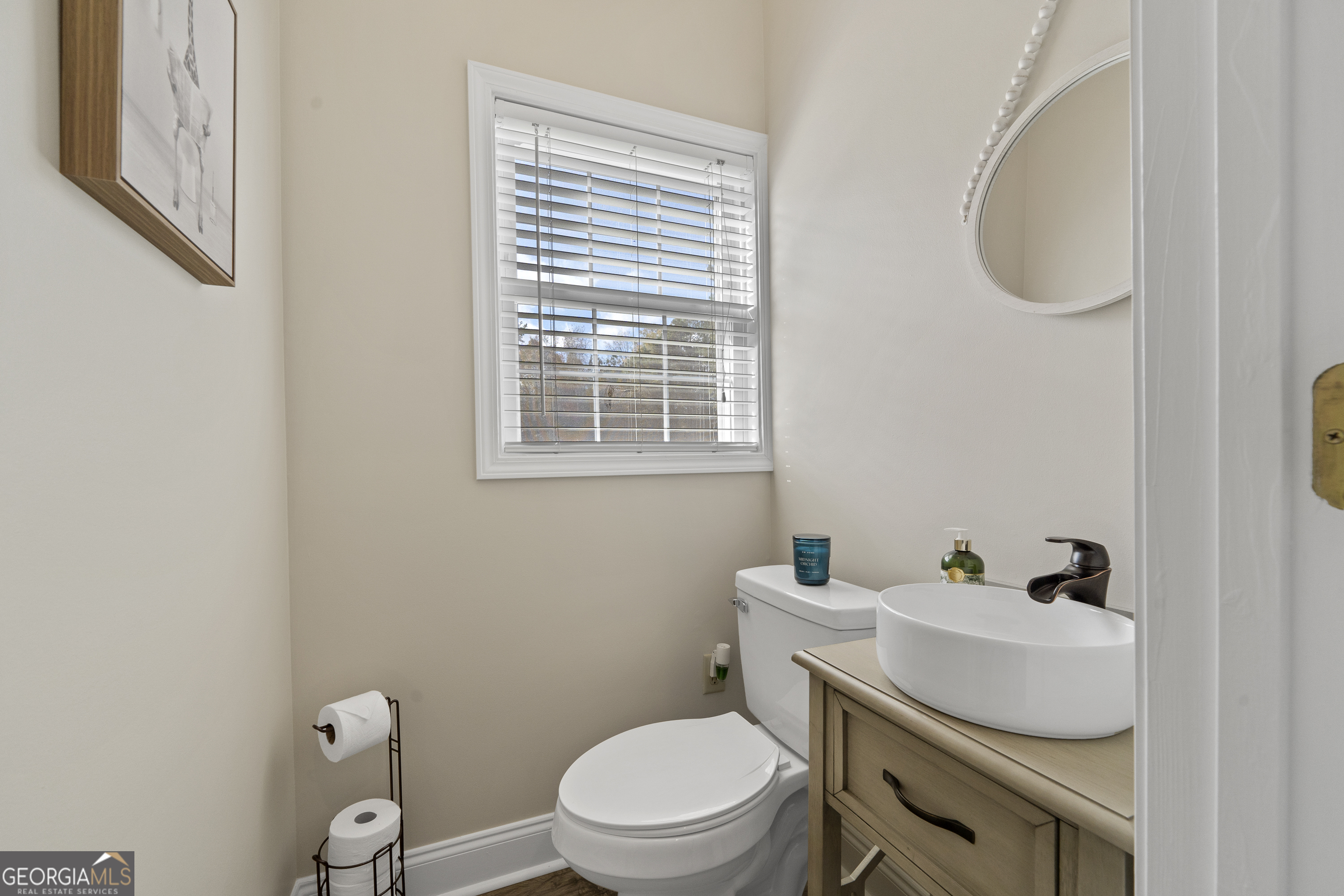 1050 Sugar Creek Church Road Madison, GA 30650 - Photo 31 of 60 a bathroom with a toilet a sink and a window