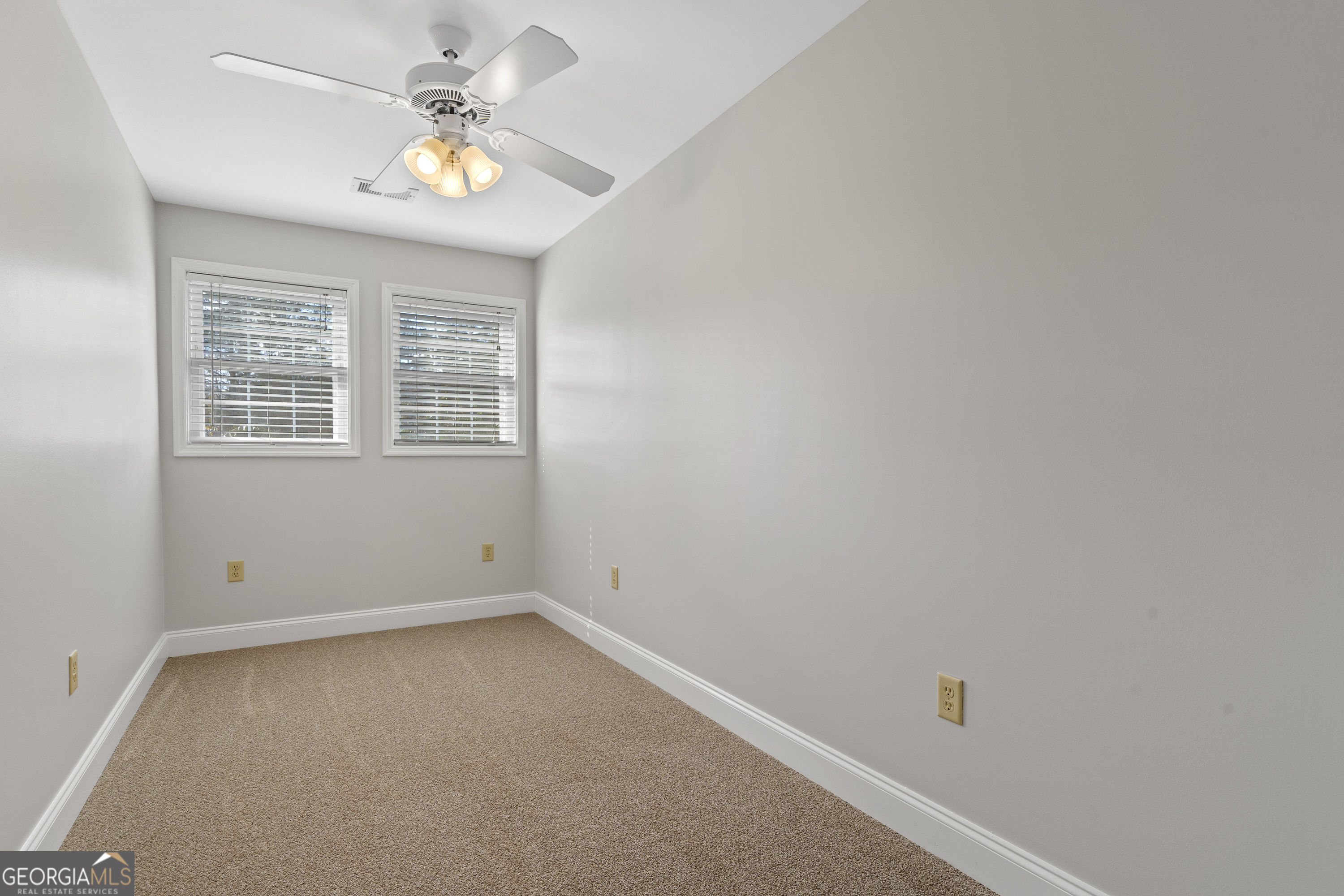 1050 Sugar Creek Church Road Madison, GA 30650 - Photo 38 of 60 an empty room with windows and ceiling fan