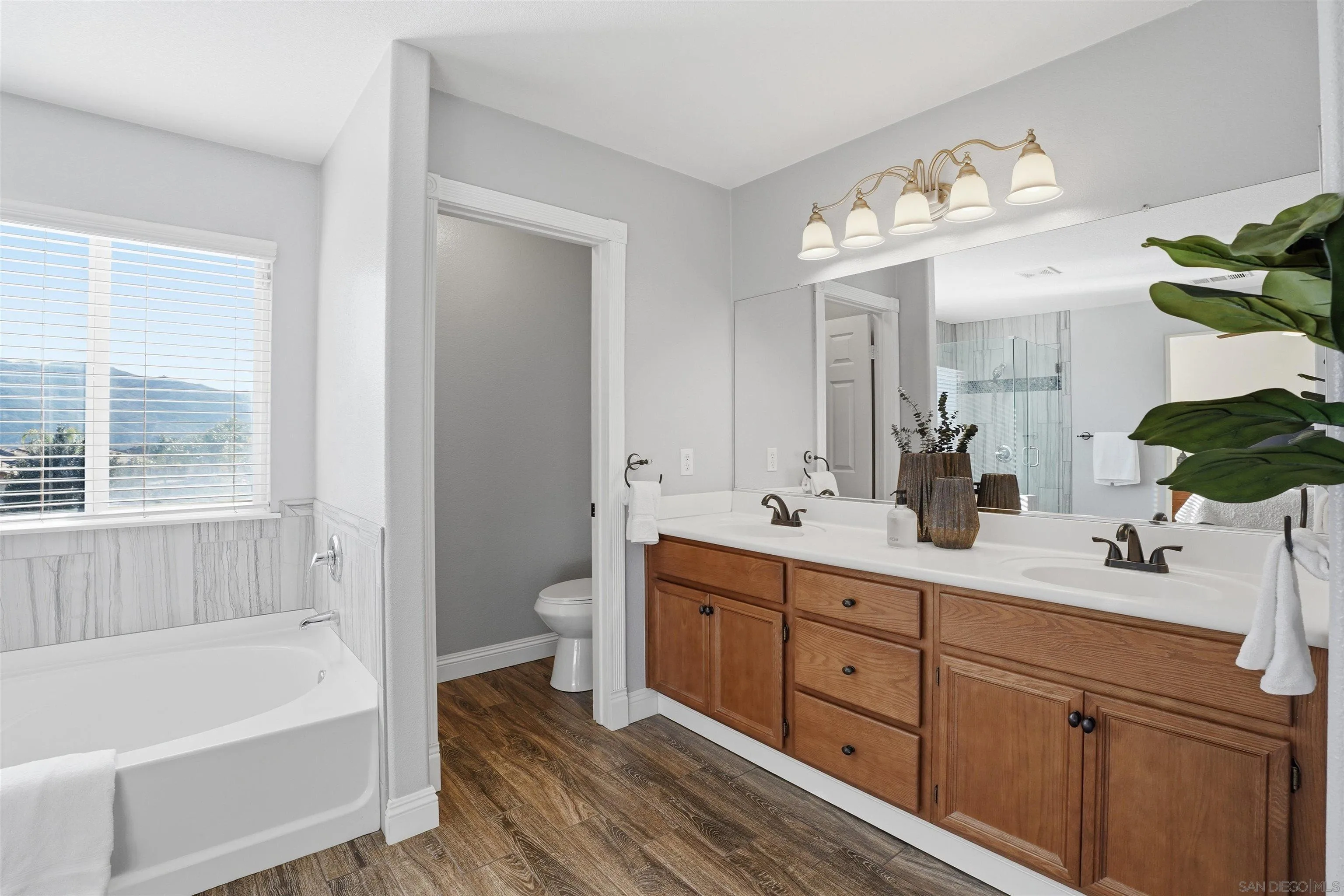 32892 Monte Drive Temecula, CA 92592 - Photo 37 of 60 a bathroom with a tub a double vanity sink and a large mirror